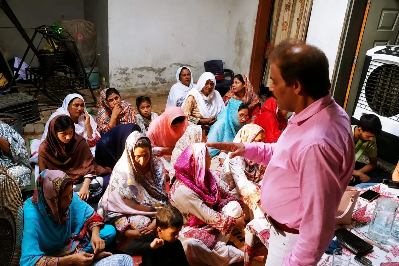 Pastor Yousaf Hussain providing community support and spiritual guidance to women and children in Pakistan
