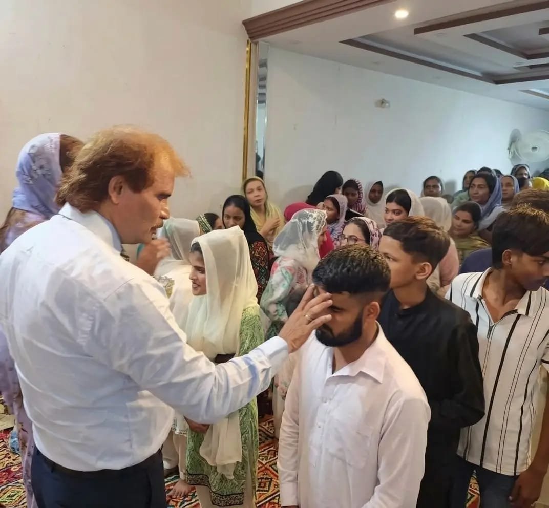 Pastor Yousaf Hussain praying for a church member at Church of Christ Assembly in Pakistan