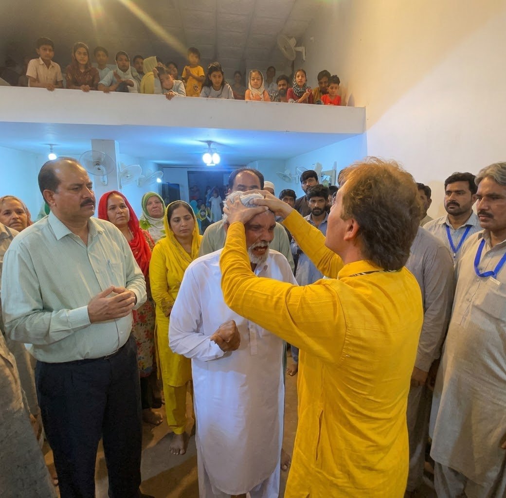 Pastor Yousaf Hussain praying for an elderly church member at Church of Christ Assembly in Pakistan