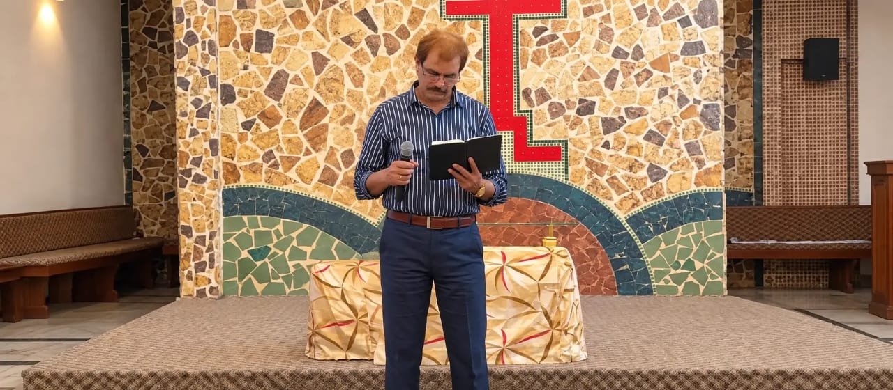 ou are welcome to visit us - Pastor Yousaf Hussain preaching with microphone and bible at Church of Christ Assembly in Pakistan